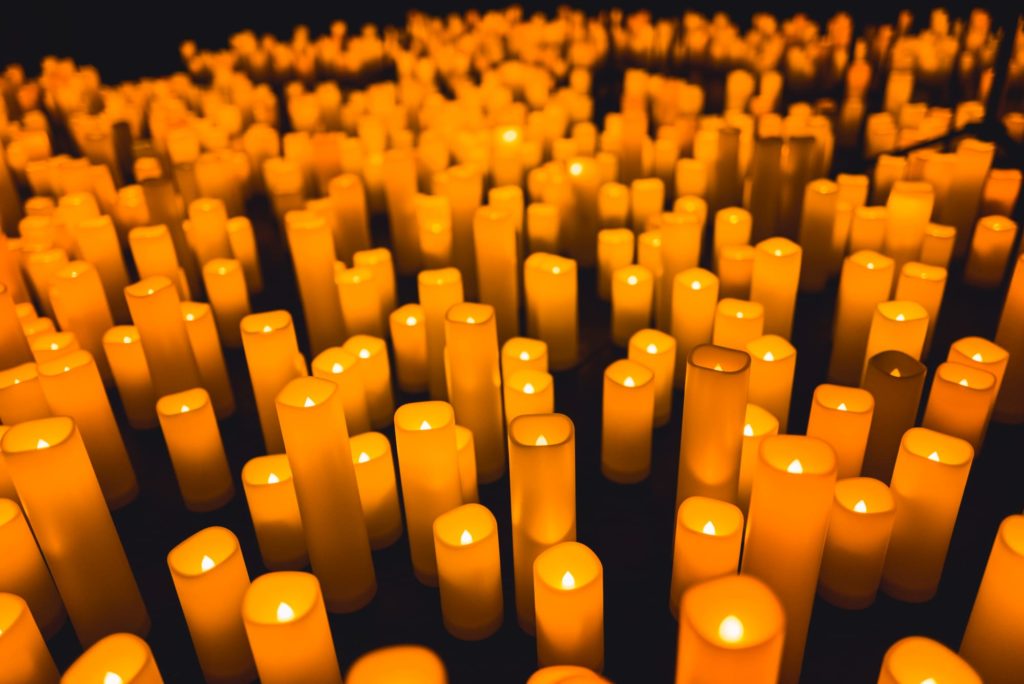 Un tas de bougies allumées parsème le sol pour un concert Candlelight.