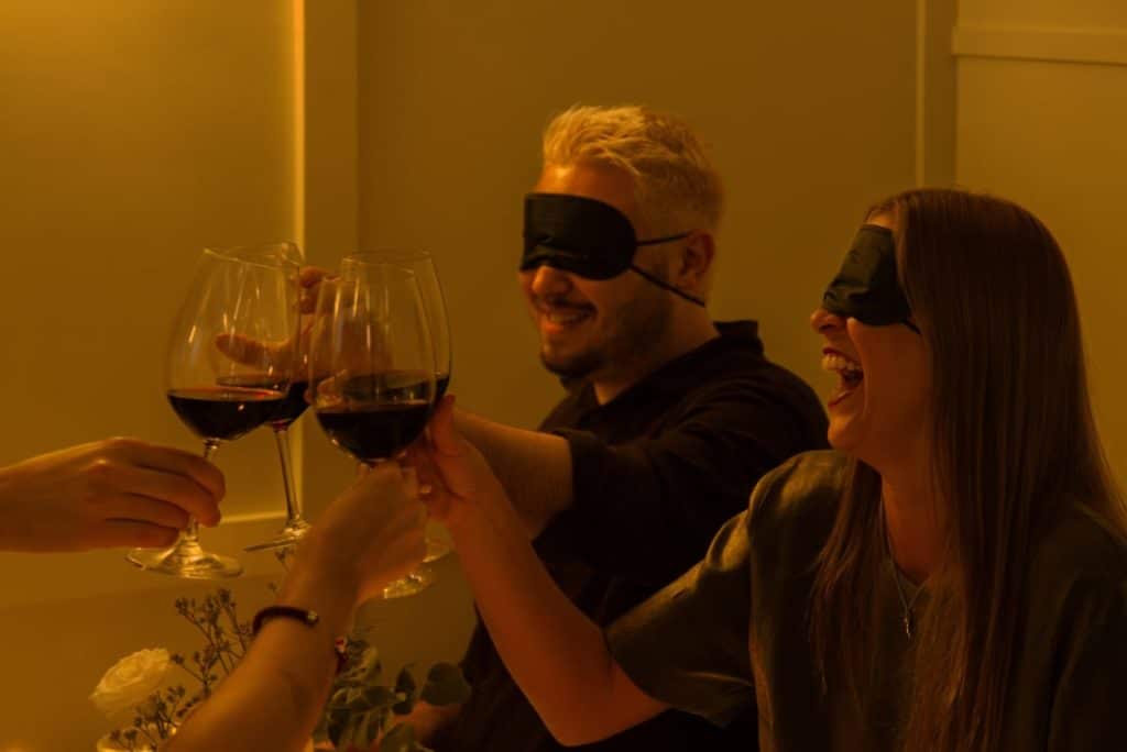 Des amis trinquent autour d'un dîner à l'aveugle Dining in the Dark les yeux bandés
